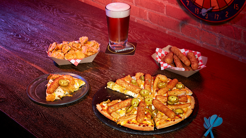 TOMBSTONE Bar Snacks Pizza is piled high with gooey mozzarella sticks, zesty fried pickles and fried onions. It’s finished off with spicy jalapeno slices and nacho cheese sauce, bringing the boldest, craziest bar bite straight to the homes of lucky consumers.